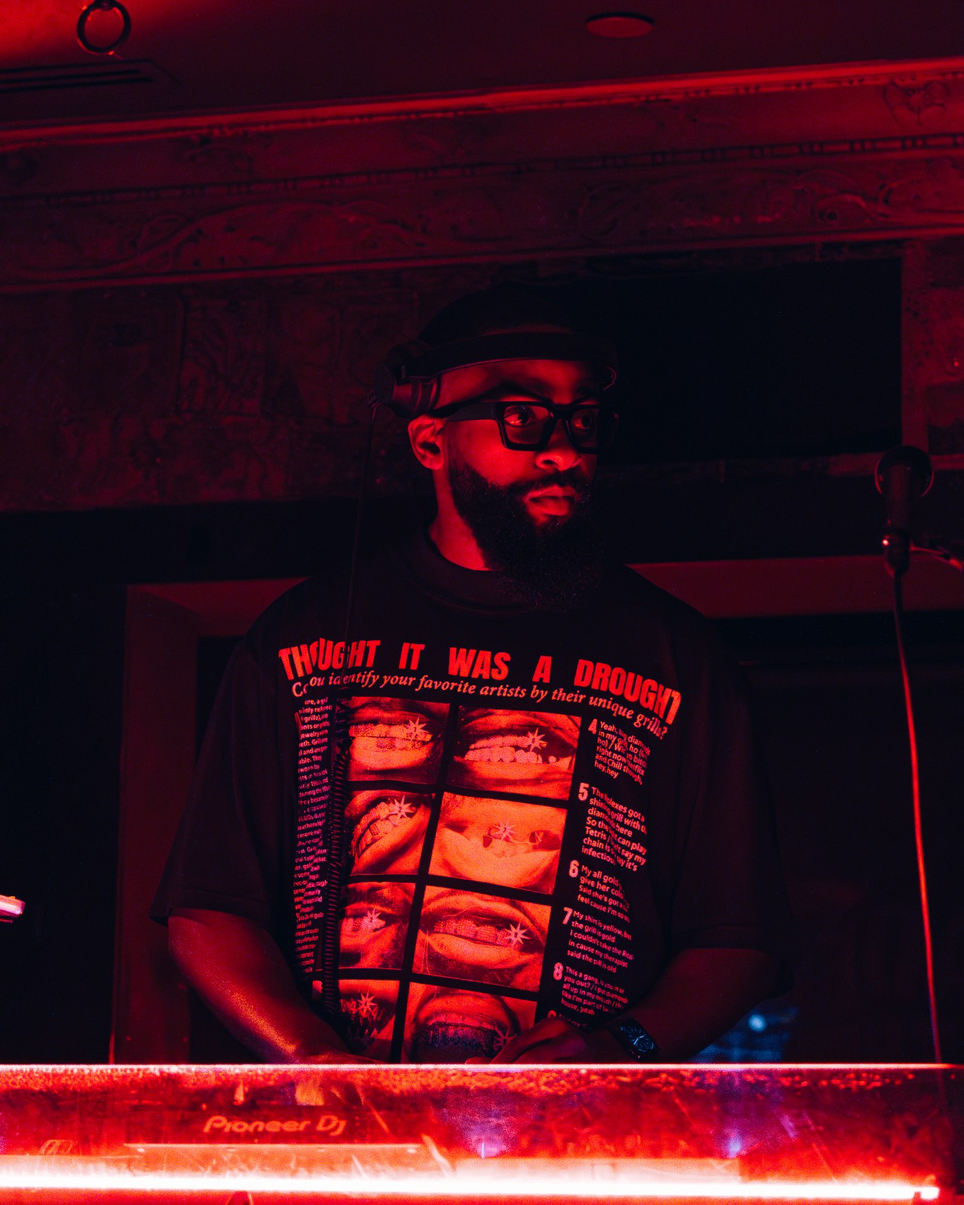DJ FLYY performing at a red-lit club event