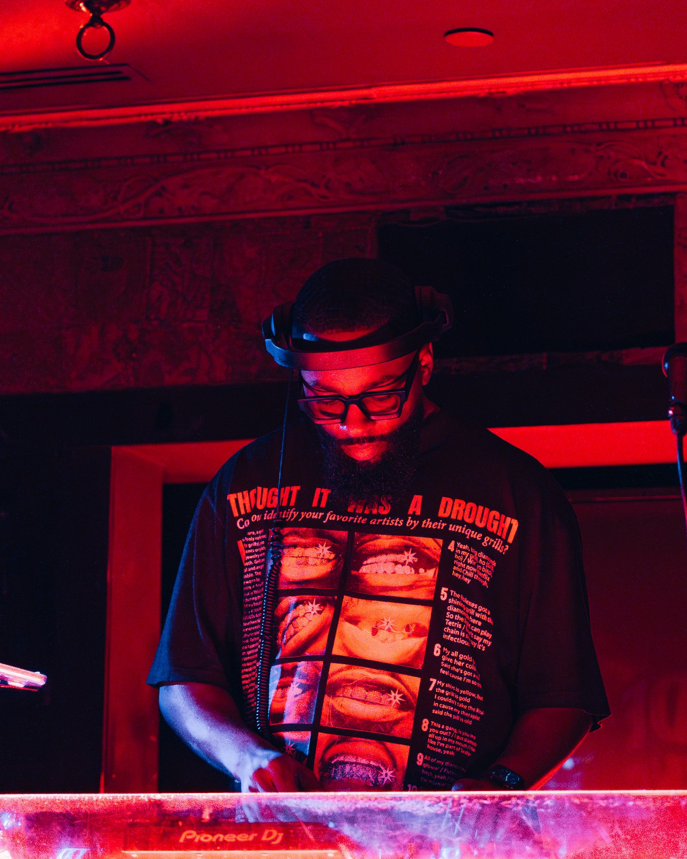 DJ FLYY performing at a red-lit club event