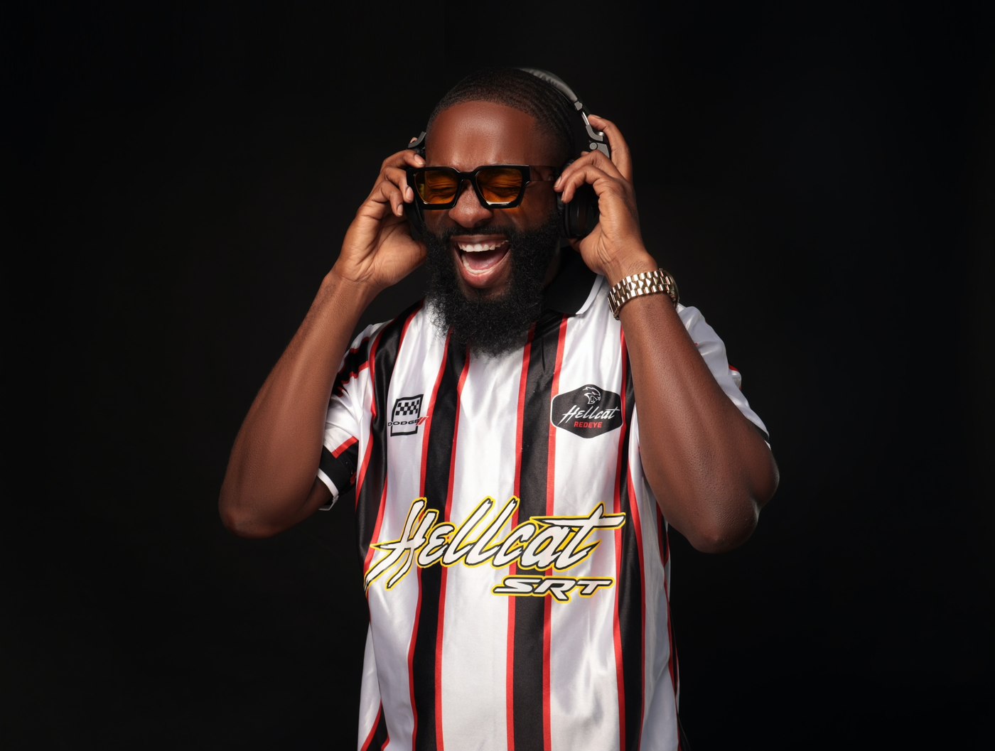 DJ FLYY laughing while adjusting his headphones