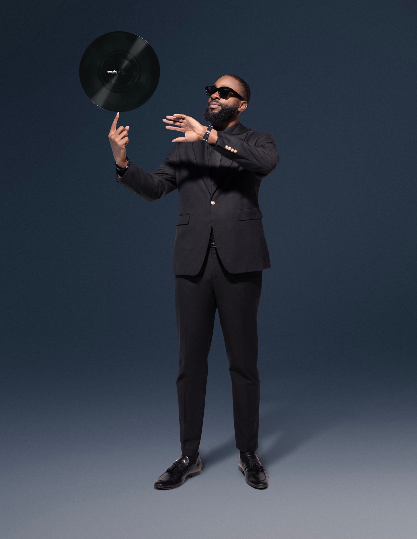 DJ FLYY tossing a vinyl record in a studio portrait